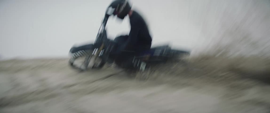 A man turns sharply on a dirt hill on his dirt bike