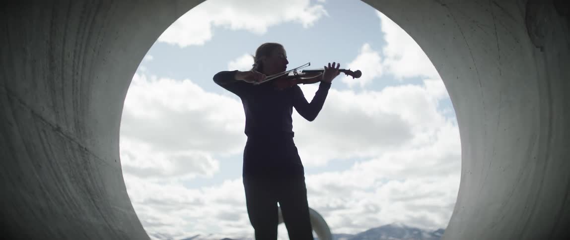 A woman is performing with a violin