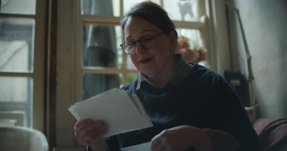 Woman sitting in the couch looking at photos at home