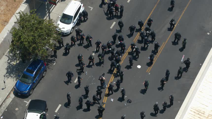 Police move around as two people embrace in center of street and another is led away by police