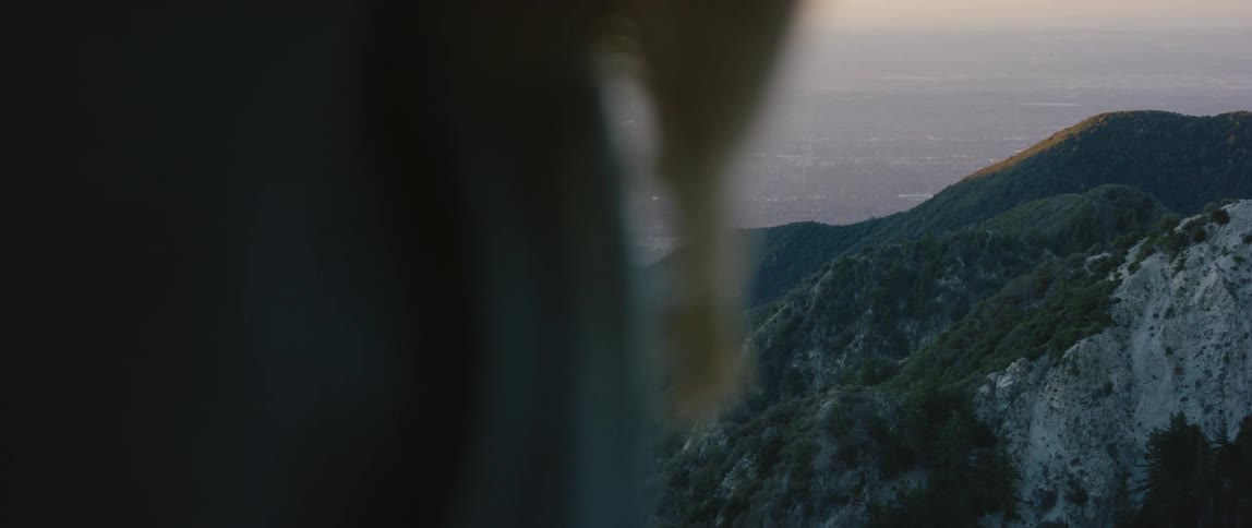 Person standing in front of the mountains at sunset