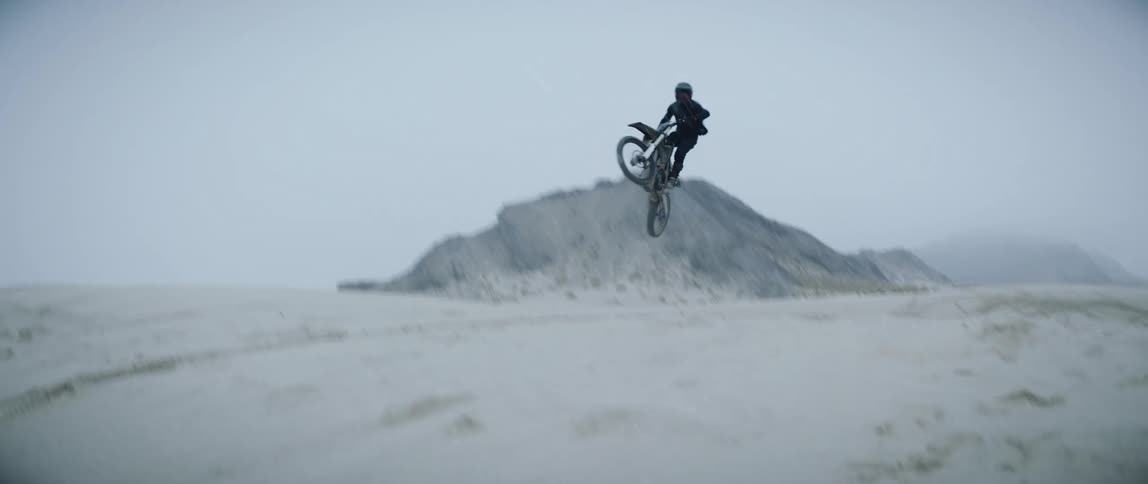 A motocross racer jumps his motorcycle in the desert