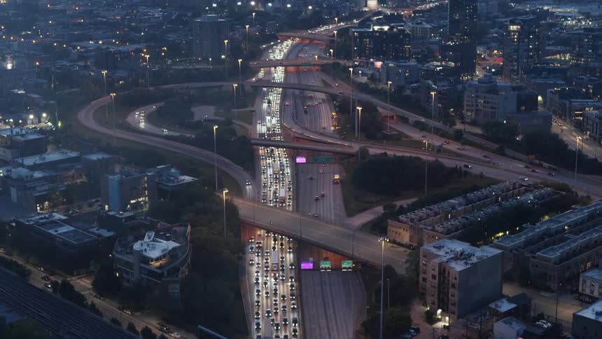 Vehicles driving on the highway going through the city at sunset