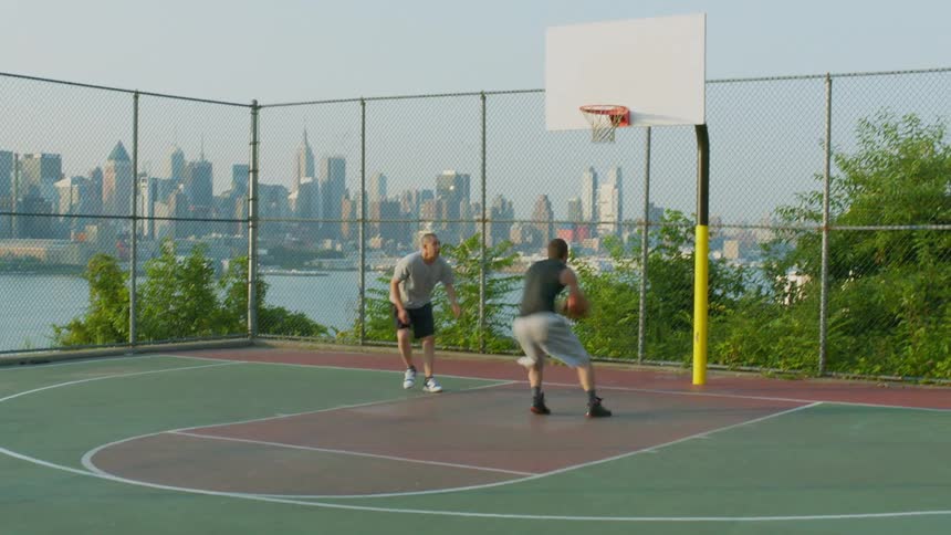 A basketball court with a man dunking on the other player