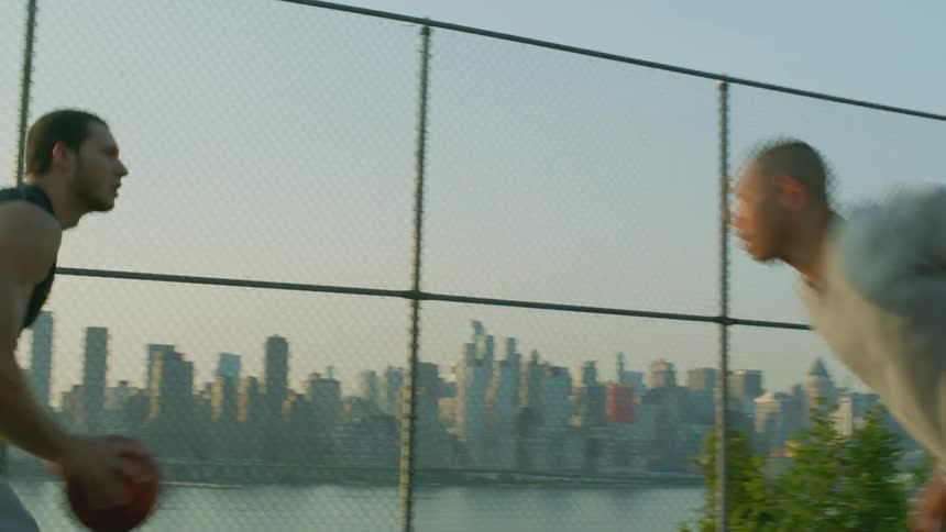 Two men playing basketball on an outdoor court