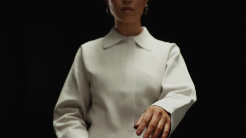 A woman with earrings in a room with a wall in the background