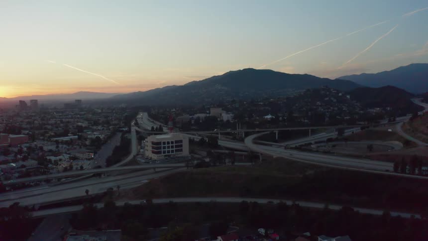 Aerial view of a city at the foot of a mountain at sunset
