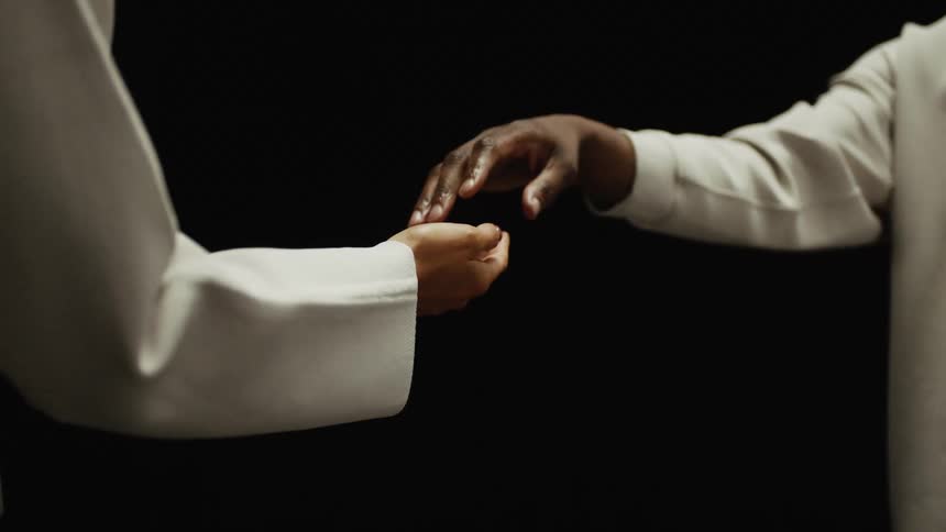 A man and a woman reaching their hands closer together slowly