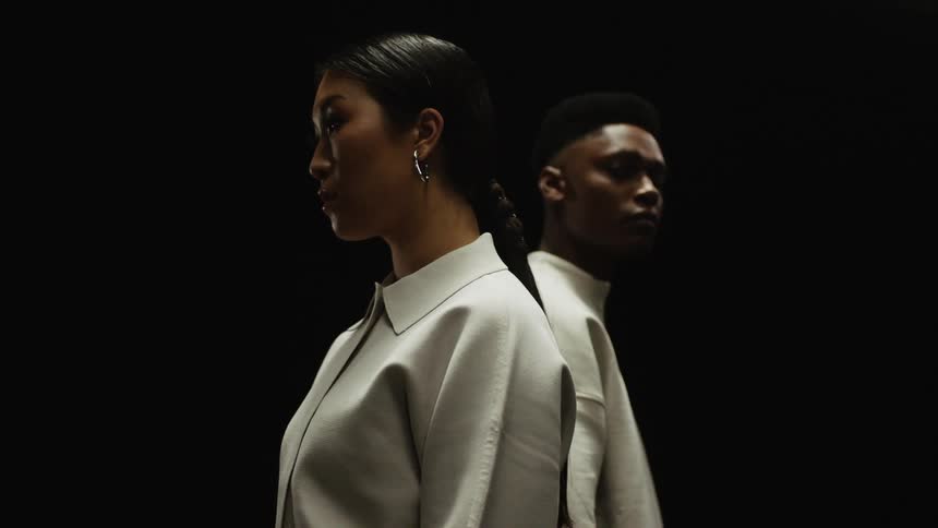 A young man and woman pose for the camera wearing uniquely fashionable clothing