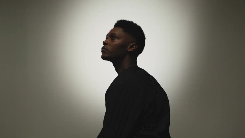 A man is sitting in an empty room next to a wall