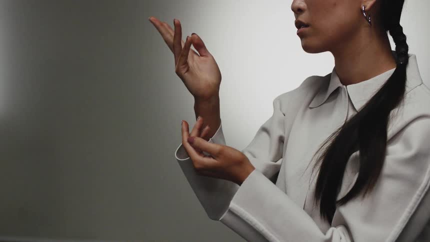 A woman slowly twists her hands to examine them from every angle