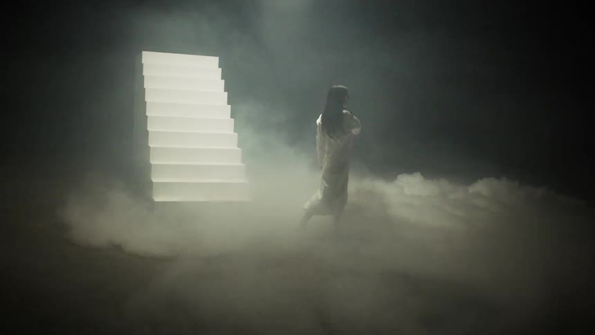 A woman is dancing next to a staircase