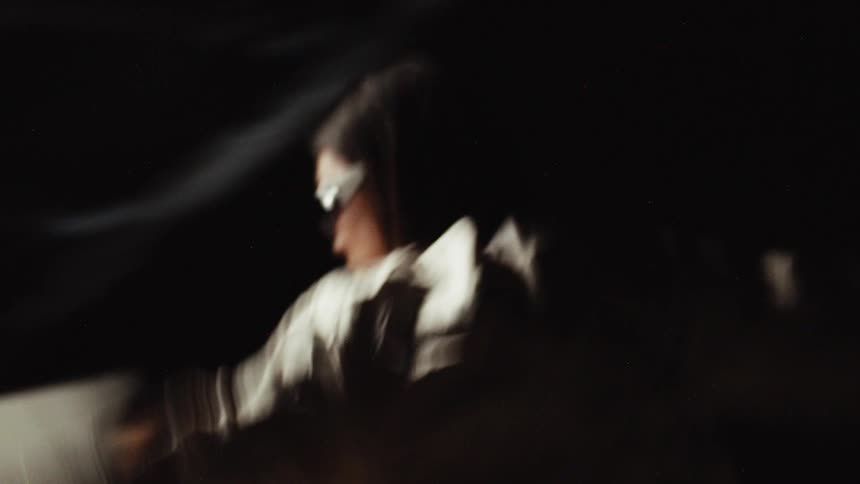 A woman wearing sunglasses moving and dancing around in a circle