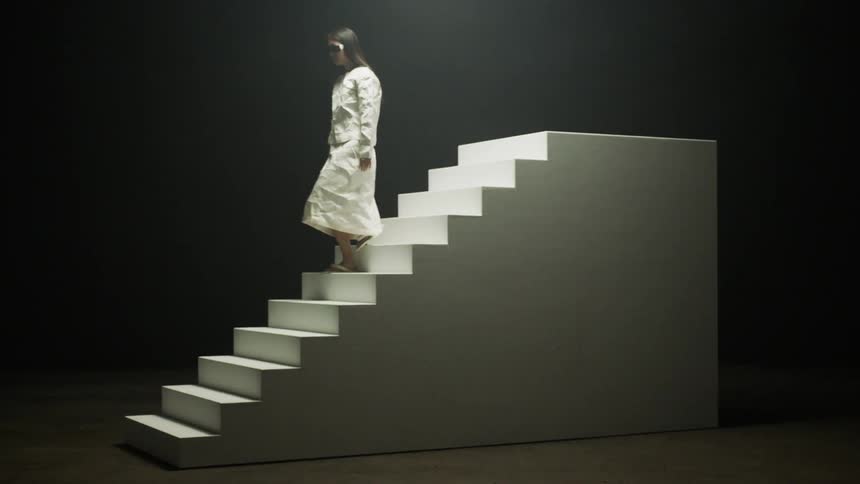 A woman is walking down a flight of stairs