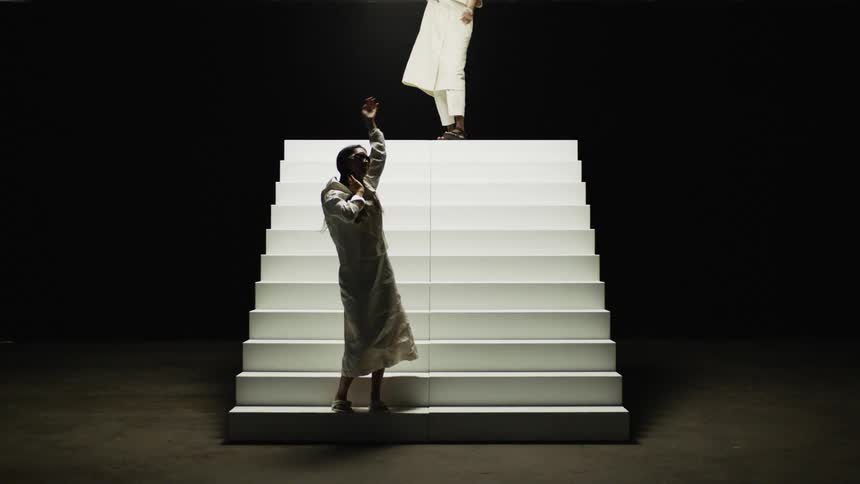 A woman is dancing next to a staircase