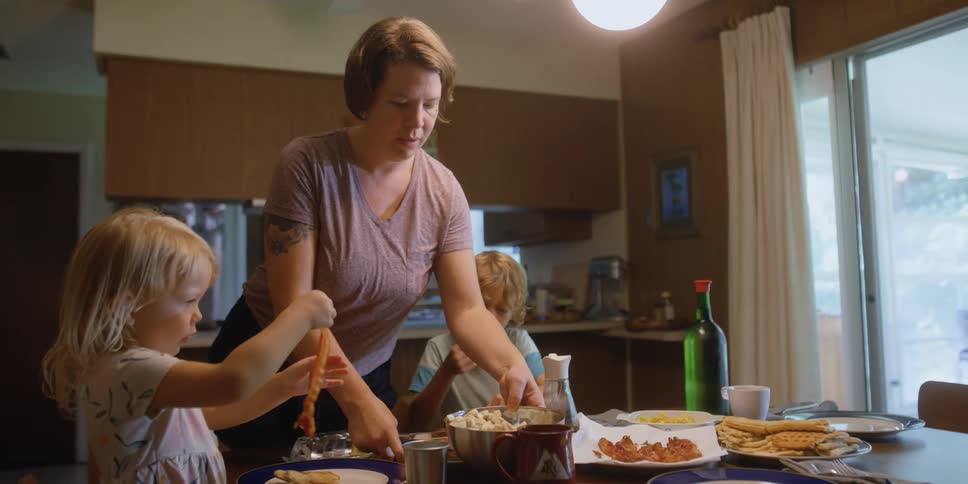 A woman putting food down onto the table