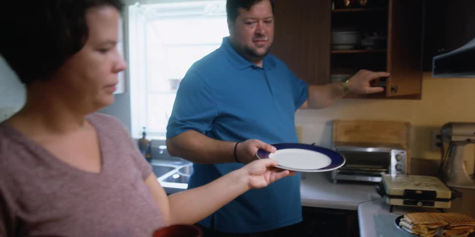 Man and woman are in a kitchen cooking food together