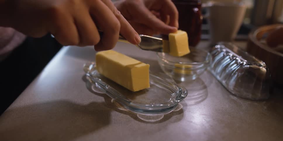A person is cutting peices of butter