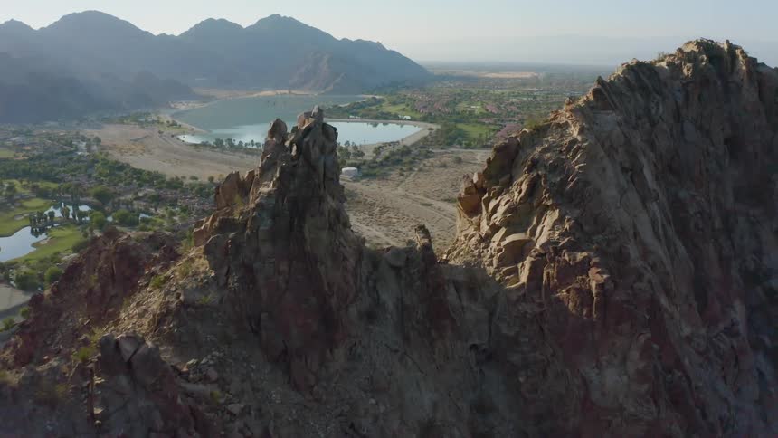 Lake valley surrounded by mountains under a hazy sky