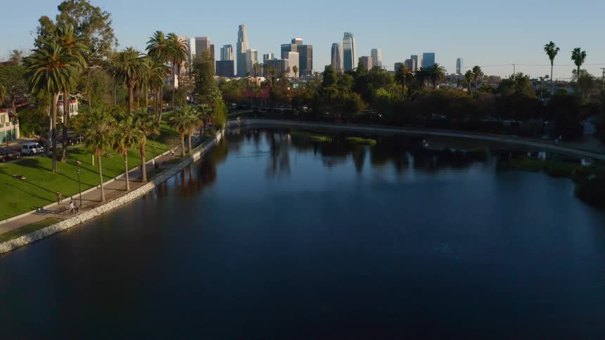 People walk along a riverfront trail that leads to downtown