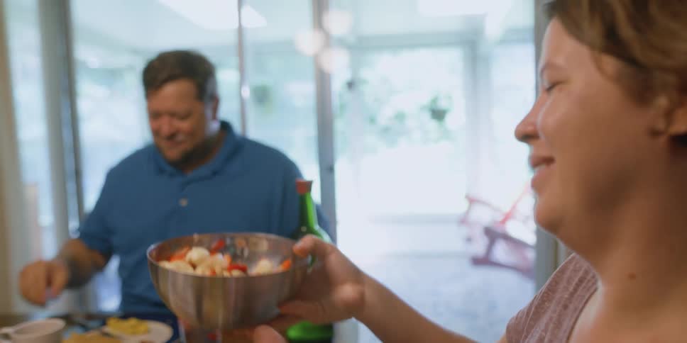 A man and woman eating food at a table