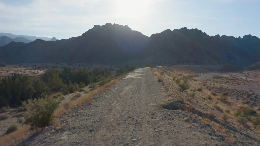An aerial view of a dirt road area towards some mountains