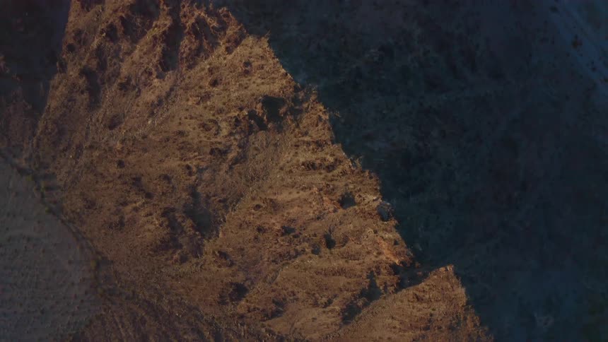 Mountain on one side of ridge sits in light while the other side sits in shadow