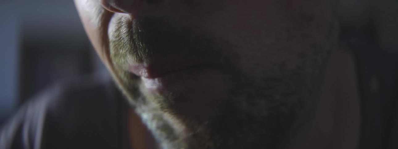 A man places a small mushroom into his mouth and proceeds to chew it