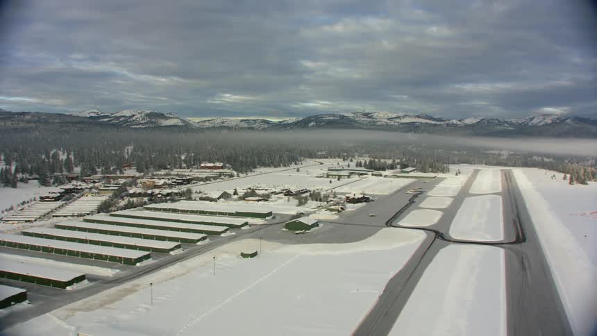 A snowy airport sits on the water front in the mountains
