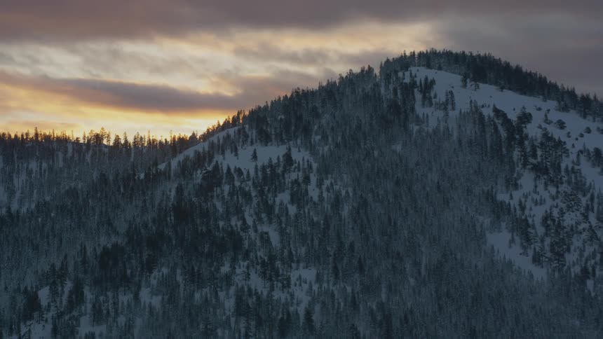 Aerial view of the snow covered slopes of a mountain at sunset