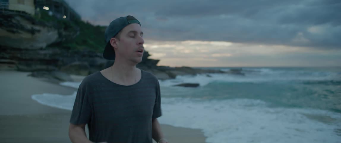 A man runs along the quiet beach beside the ocean water
