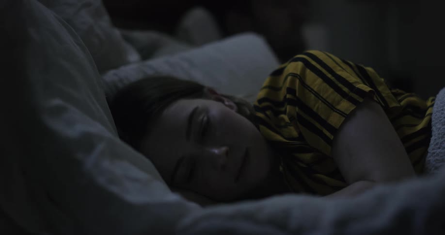 A woman tucks her her behind her ear while going to sleep