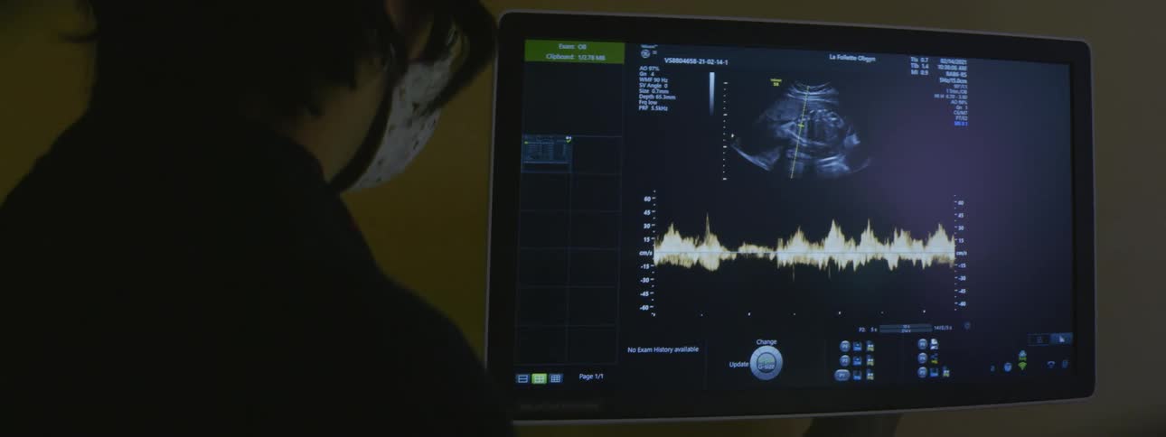A man stands watching a screen with a radar display