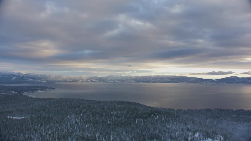 The shore by the lake is covered with snow