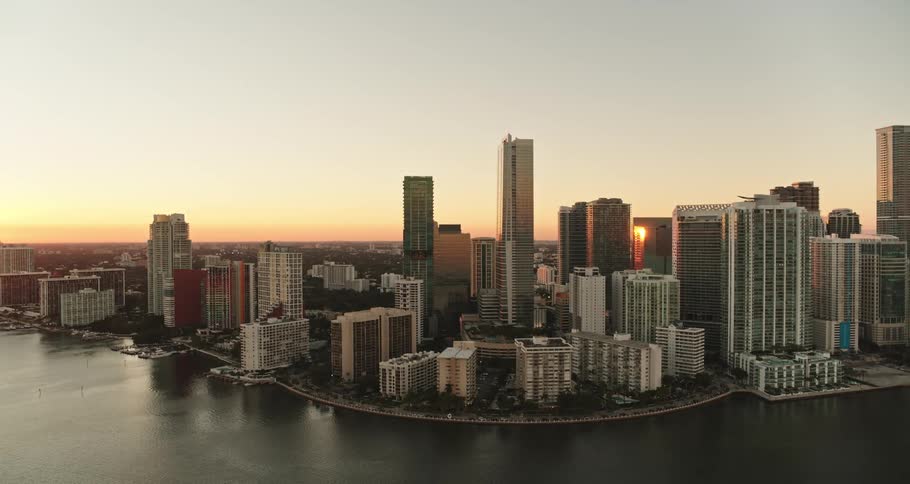 A city skyline is seen as the sun is setting
