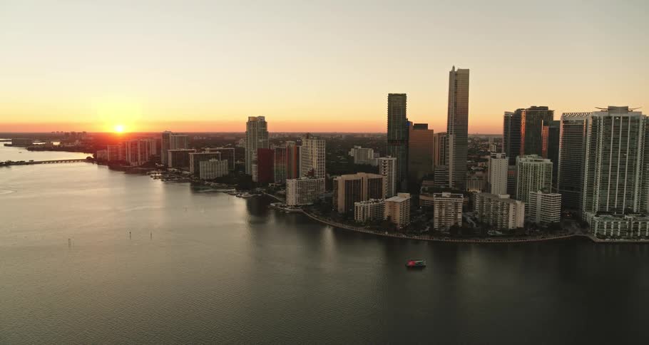 A boat sails on the waterway in front of a downtown city skyline
