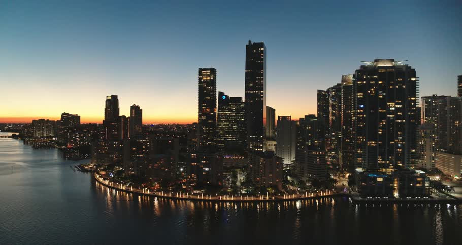 City lights glow and shimmer reflecting off the water in a city skyline