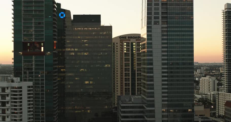 A city skyline is revealed as the sun rises to a smoggy morning