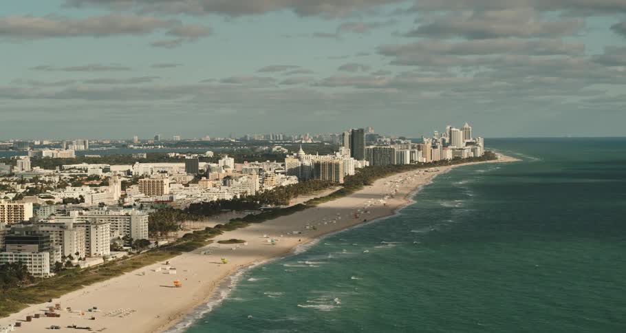 A beach on the edge of a city with large buildings during the day