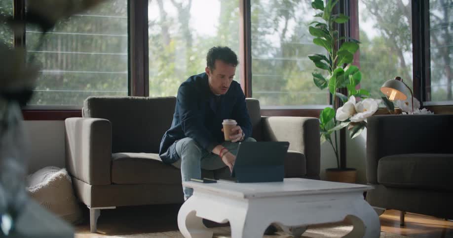 A man typing on a laptop in a room