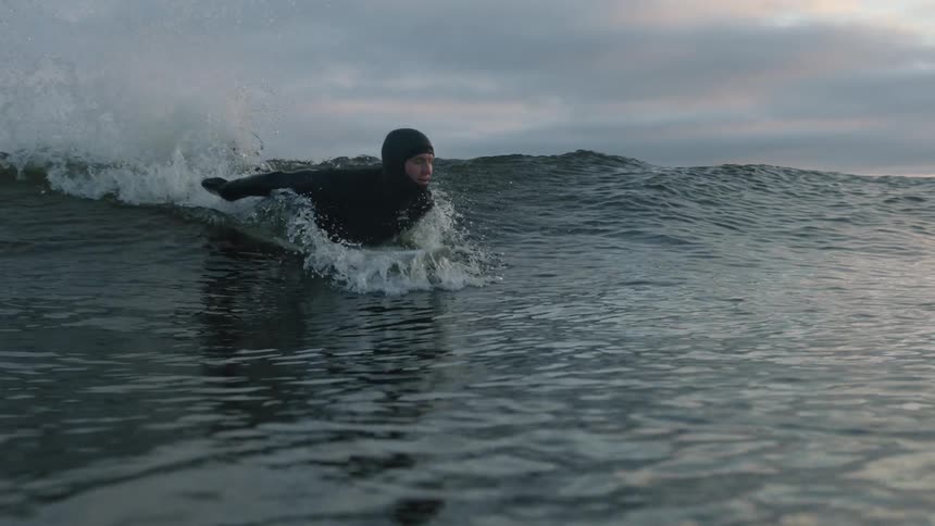 A man in a wet suit surfs