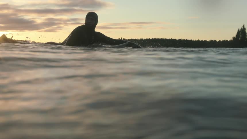 A surfer paddles out at dawn