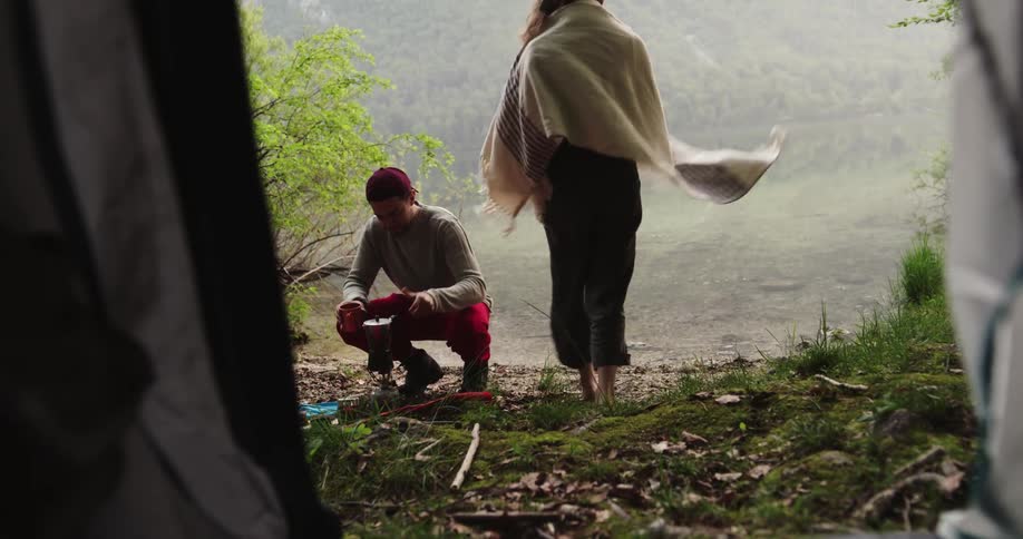 A man and woman walking out of tent