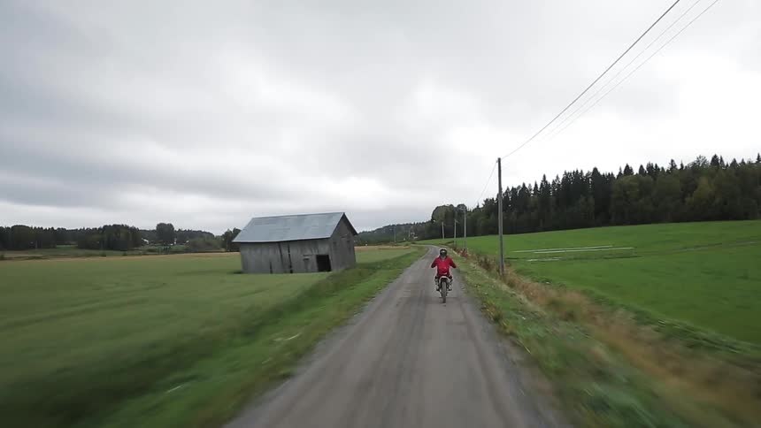 Person riding a small motorbike on a country road