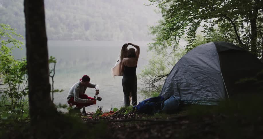A man and woman kiss by the tent