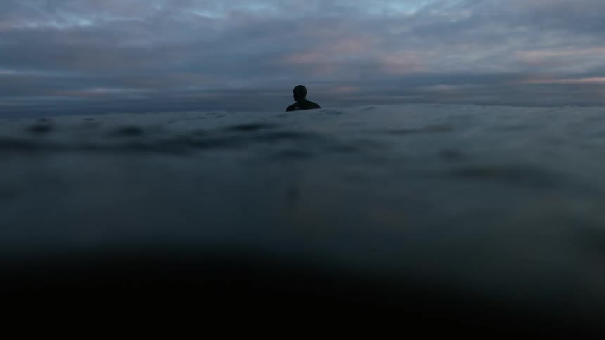 A man stands in wavy water