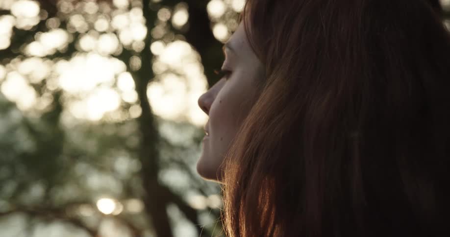 Young woman drinking a hot beverage from a cup outdoors in the morning