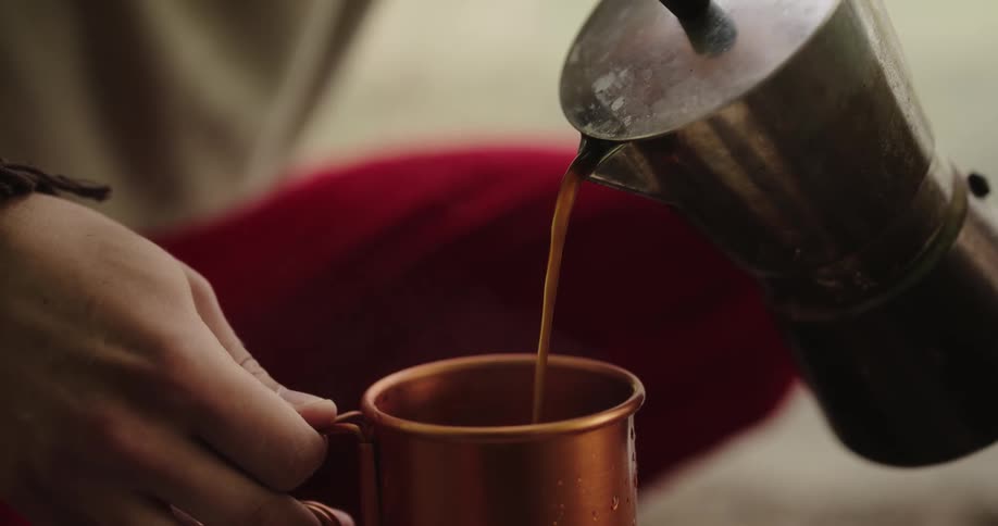 A person is pouring coffee into a cup