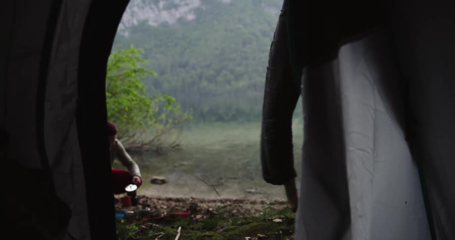 A woman and man are camping in the wilderness
