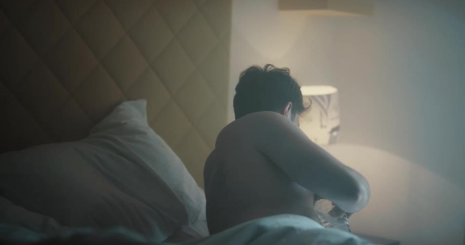 A man drinking water in bed then passing out